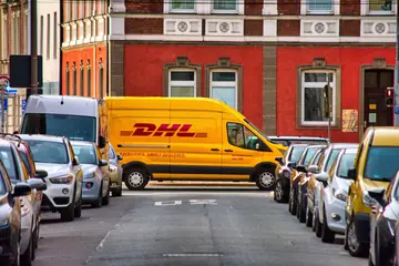 中古ノートパソコンの海外向け卸販売とDHL Express国際配送のイメージ。輸出パートナー向けに小ロットから相談可能